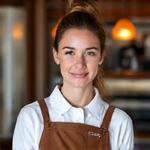 Smiling female barista, Elara Vance, with a World Barista Championship medal.