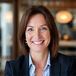 Eleanor Vance, Head of Events at Sterling Corp., smiling at a catered corporate event with Daily Grind & Bean Co. mobile coffee.